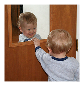 Child looking at self in mirror